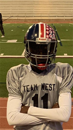 This is our student posing in his football uniform. The uniform reads "Team West."